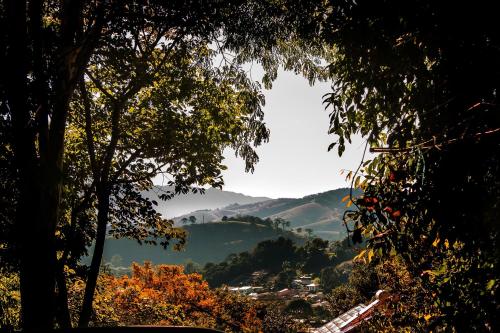 vista su una valle in lontananza con alberi di Pousada Bonani a Itanhandu