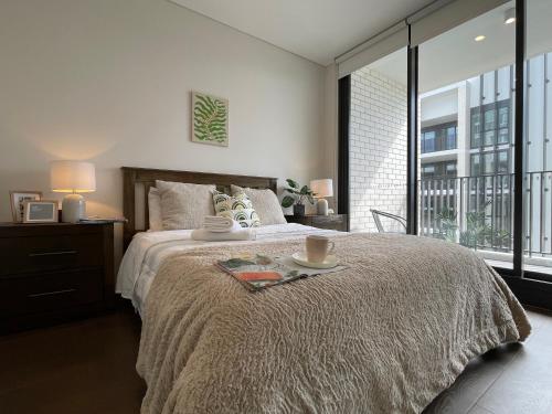 a bedroom with a large bed and a large window at Nearby stadium & New 3b2b Apt & Free parking in Sydney