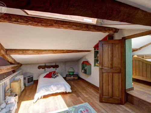 an attic bedroom with a bed and wooden beams at Découvrez ce gîte champêtre avec spa, sauna, piscine et jardin privatif à Essertines-en-Donzy - FR-1-496-200 in Essertines-en-Donzy