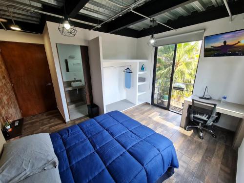 a bedroom with a large blue bed and a desk at R09-C46 STUDIO frente al ITESM CEM Estudiantes Familias Empresas Ejecutivos Turistas Nómadas BIENVENIDOS!!! UBICACIÓN ESTRATÉGICA 10min Izcalli-15min Esmeralda-20min Sátelite-25min AIFA in Mexico City