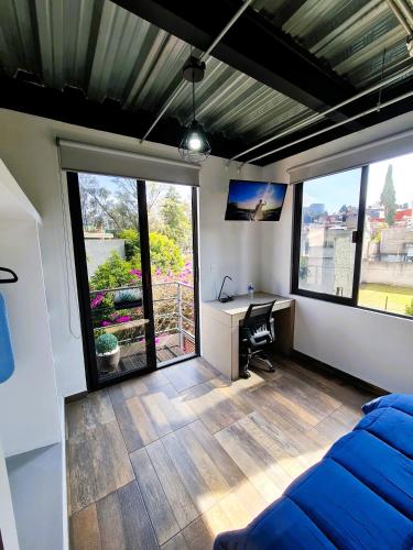 a room with a bed and a desk and windows at R09-C46 STUDIO frente al ITESM CEM Estudiantes Familias Empresas Ejecutivos Turistas Nómadas BIENVENIDOS!!! UBICACIÓN ESTRATÉGICA 10min Izcalli-15min Esmeralda-20min Sátelite-25min AIFA in Mexico City