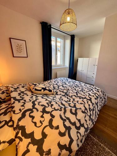 une chambre avec un lit avec une couette noire et blanche dans l'établissement Appartement centre ville - 4 personnes, à Saint-Dizier