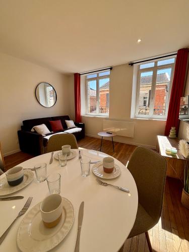 un salon avec une table et des chaises blanches dans l'établissement Appartement centre ville - 4 personnes, à Saint-Dizier