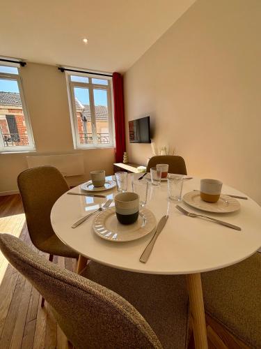 une salle à manger avec une table et des chaises blanches dans l'établissement Appartement centre ville - 4 personnes, à Saint-Dizier