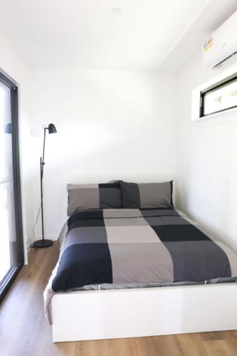 a white bedroom with a black and white bed at The Pavilion - Rarotonga in Arorangi