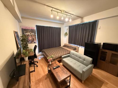 ein Wohnzimmer mit einem Bett und einer Couch in der Unterkunft ParkResidence -FIX HOME- in Sapporo