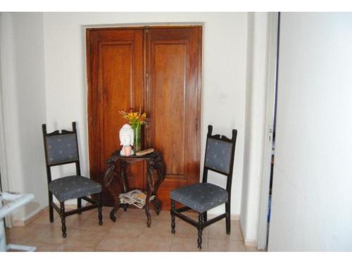 two chairs and a table in a room with a door at Casa quinta caminos del vino in San Rafael