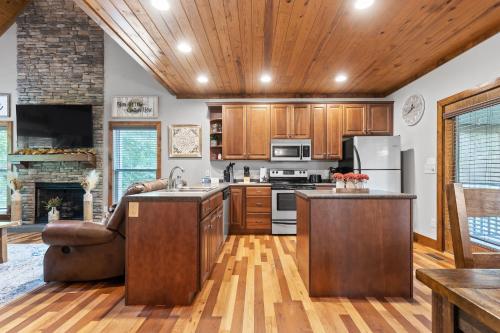 a large kitchen with wooden cabinets and a fireplace at Updated Cabin - Hiwassee Highlife in Decatur