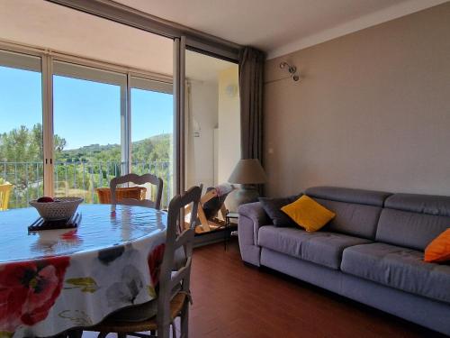 un salon avec une table et un canapé dans l'établissement Appartement à Banyuls-sur-Mer - Calme et Confort pour 4 Pers, Parking Inclus - FR-1-309-6, à Banyuls-sur-Mer