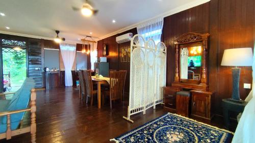 a living room with a table and a dining room at The Bukit Resort Langkawi in Kampung Padang Masirat