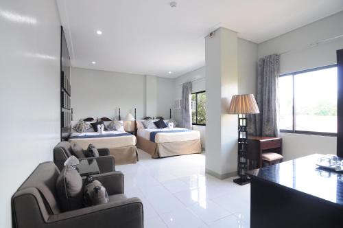 a living room with two beds and a couch at 717 Cesar Place Hotel in Tagbilaran City