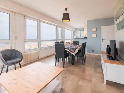 une salle à manger avec une table, des chaises et des fenêtres dans l'établissement Appartement 2 chambres avec vue mer au Touquet - FR-1-821-37, à Le Touquet-Paris-Plage