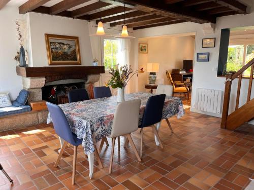 une salle à manger avec une table et des chaises et une cheminée dans l'établissement Maison lumineuse à Sauzon avec grande terrasse et jardin - FR-1-418-269, à Sauzon