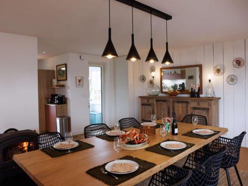 une table de salle à manger avec des assiettes de nourriture dessus dans l'établissement Maison 4 étoiles à Trégastel, proche plage pour 8 pers. avec parking - FR-1-542-74, à Trégastel