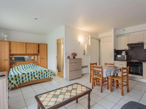 une chambre avec un lit et une table et une cuisine dans l'établissement Studio confortable avec jardin et parking à Cambo-les-Bains - FR-1-4-703, à Cambo-les-Bains