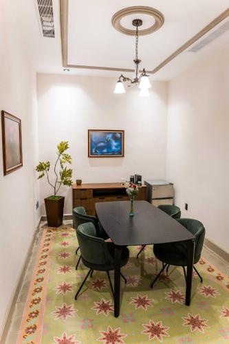 a dining room with a table and chairs on a rug at Hotel Guidi Linares in Linares