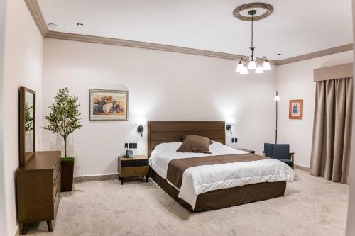 a bedroom with a large bed and a table at Hotel Guidi Linares in Linares