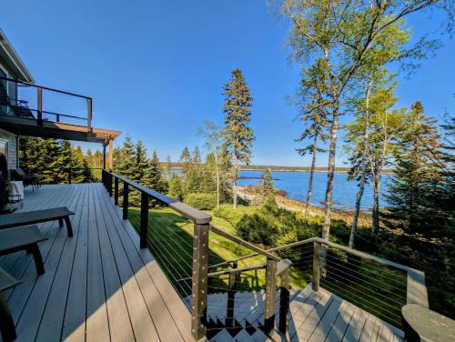 una terrazza in legno con vista sull'acqua di Oceanfront Crackling Cove Cottage Family firer pit slleeps 6 a Gouldsboro