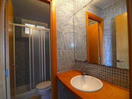 a bathroom with a sink and a toilet and a mirror at Spacious duplex Apartment in Estartit in L'Estartit