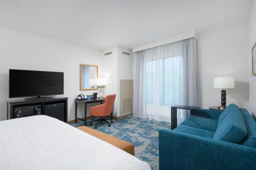 a hotel room with a bed and a couch and a television at Hampton Inn & Suites Chattanooga/Hamilton Place in Chattanooga