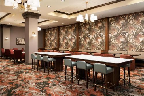 a restaurant with tables and chairs in a lobby at Embassy Suites North Charleston Airport Hotel Convention in Charleston
