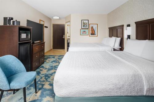 a hotel room with two beds and a chair at Hampton Inn Chicago-Midway Airport in Chicago