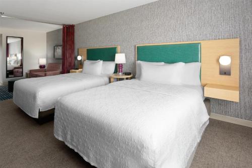 a hotel room with two beds and a desk at Home2 Suites Dover in Dover