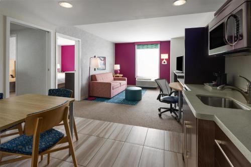 a kitchen and living room with a table and chairs at Home2 Suites Dover in Dover