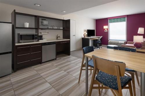 a kitchen and dining room with a table and chairs at Home2 Suites Dover in Dover