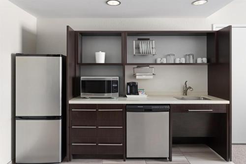 a kitchen with a refrigerator and a microwave at Home2 Suites Dover in Dover