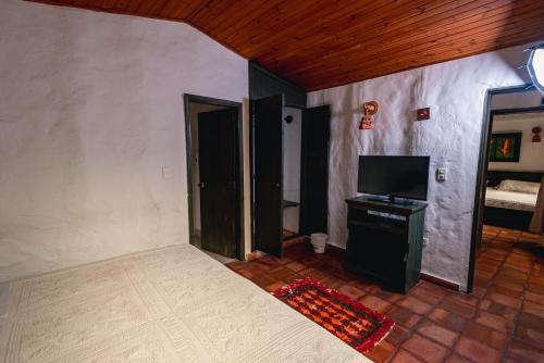 a room with a bed and a flat screen tv at HOTEL COMPOSTELLA in Paipa