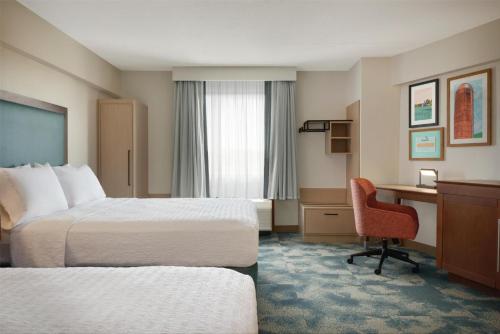 a hotel room with two beds and a desk at Hampton Inn Lancaster in Lancaster