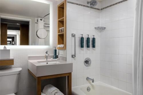 a bathroom with a sink and a tub and a toilet at New York Hilton Midtown in New York