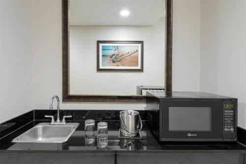 a kitchen with a microwave and a sink at DoubleTree by Hilton Hotel West Palm Beach Airport in West Palm Beach