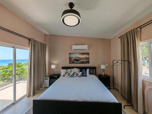 a bedroom with a large bed and a large window at Luxury Oceanfront Villa with Heated Pool, Jacuzzi, AC, BBQ, Starlink Wi-Fi, Chef's Kitchen, Staff Included, Mountain Views, Near El Quemaito, San Rafael, and Los Patos Beach in Santa Cruz de Barahona