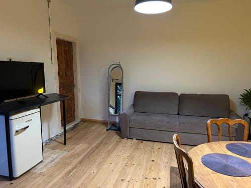 una sala de estar con un sofá y una mesa en Sisters Beach Apartments, en Liepāja