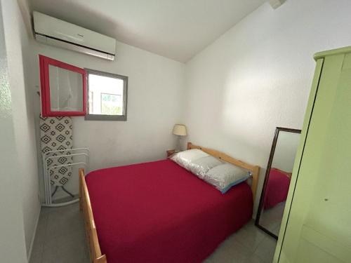 - une petite chambre avec un lit rouge et une fenêtre dans l'établissement Maisonette avec clim et parking privé à Argelès-sur-Mer - FR-1-837-9, à Argelès-sur-Mer