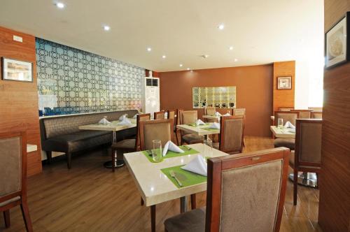 a dining room with tables and chairs in a restaurant at 717 Cesar Place Hotel in Tagbilaran City
