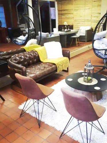 a living room with a couch and a table and chairs at The Gallery Guest House in Port Elizabeth