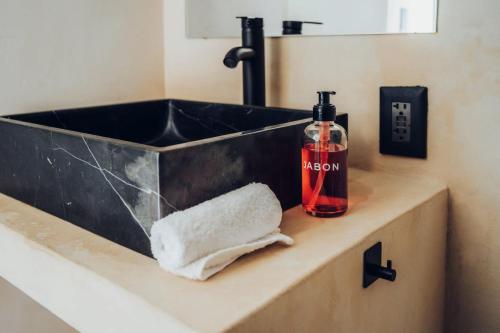 a bathroom sink with a bottle of alcohol and a towel at Wander Cabins Dehe 