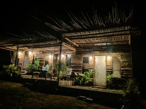a wooden house with lights on it at night at Tribu Kihud "Experience Simple Living" in Siquijor