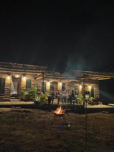 a group of people sitting around a fire in front of a house at Tribu Kihud "Experience Simple Living" in Siquijor