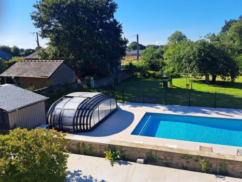 une petite piscine avec un dôme à côté d'une maison dans l'établissement Ty breizh, à Plumelec