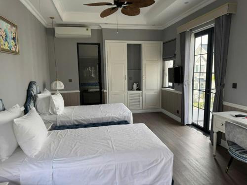 a bedroom with two beds and a ceiling fan at Onsen mineral bath, Vuon Vua, Thanh Thuy, Phu Tho in Phú Thọ