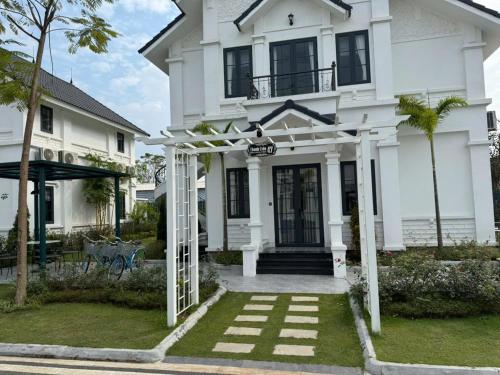 a white house with an archway in front of it at Onsen mineral bath, Vuon Vua, Thanh Thuy, Phu Tho in Phú Thọ