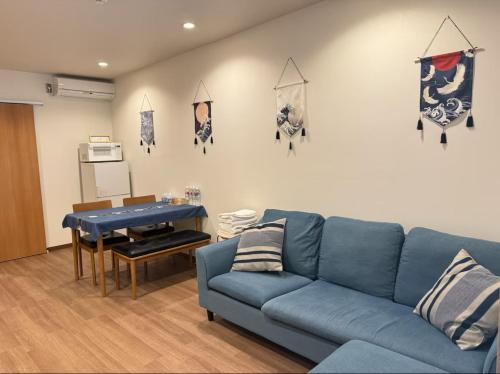a living room with a blue couch and a table at 盛-大正 in Osaka