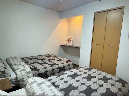 a small room with two beds and a cabinet at 盛-大正 in Osaka