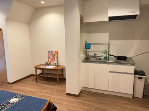 a small kitchen with a sink and a table at 盛-大正 in Osaka