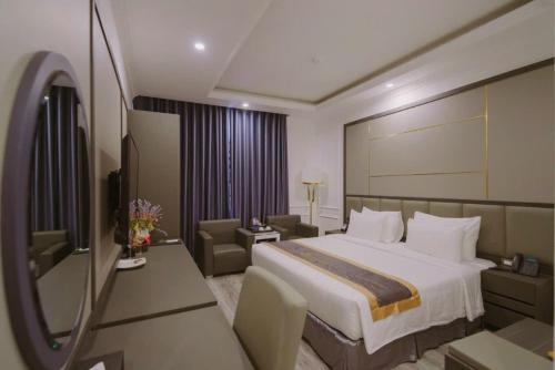 a hotel room with a large bed and a chair at Sen plaza Hotel in Yên Thành