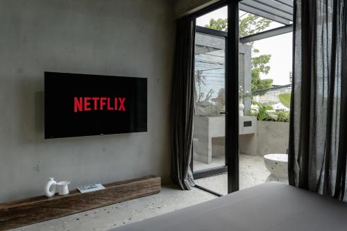 a bedroom with a netflix sign on the wall at Predmet Babakan Canggu Bali in Dalung